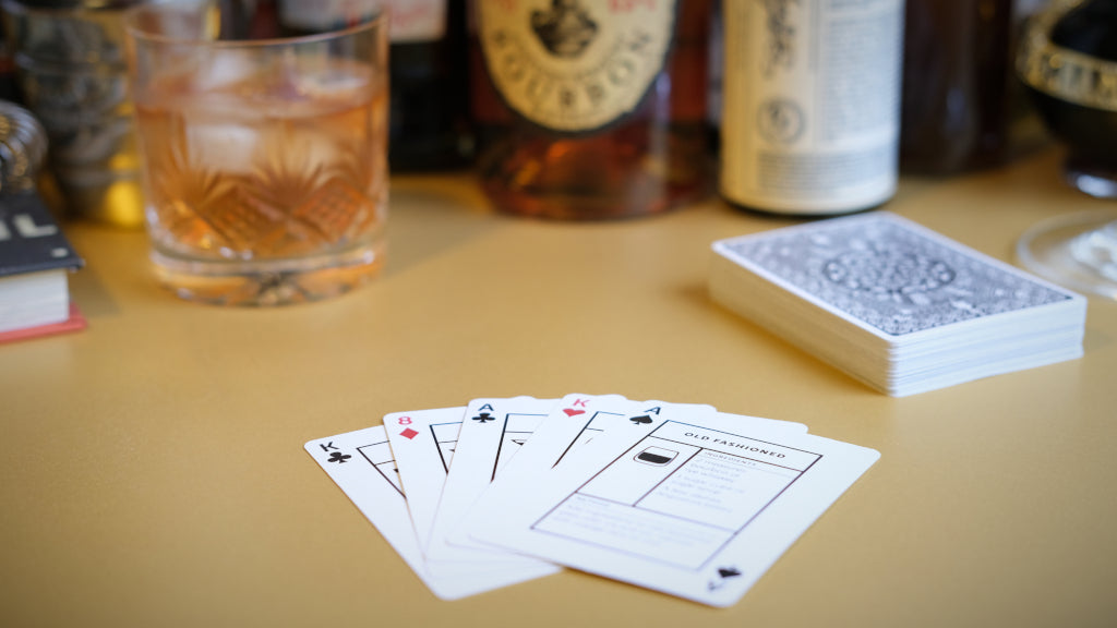 Cocktail Cards playing cards - laid out as poker hand with whiskey. Cover image for the Kickstarter video