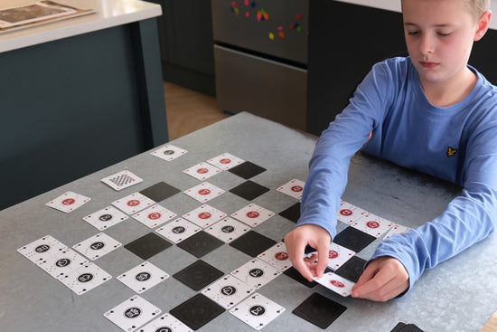 One Deck Game Cards being used to play chess on a metal table