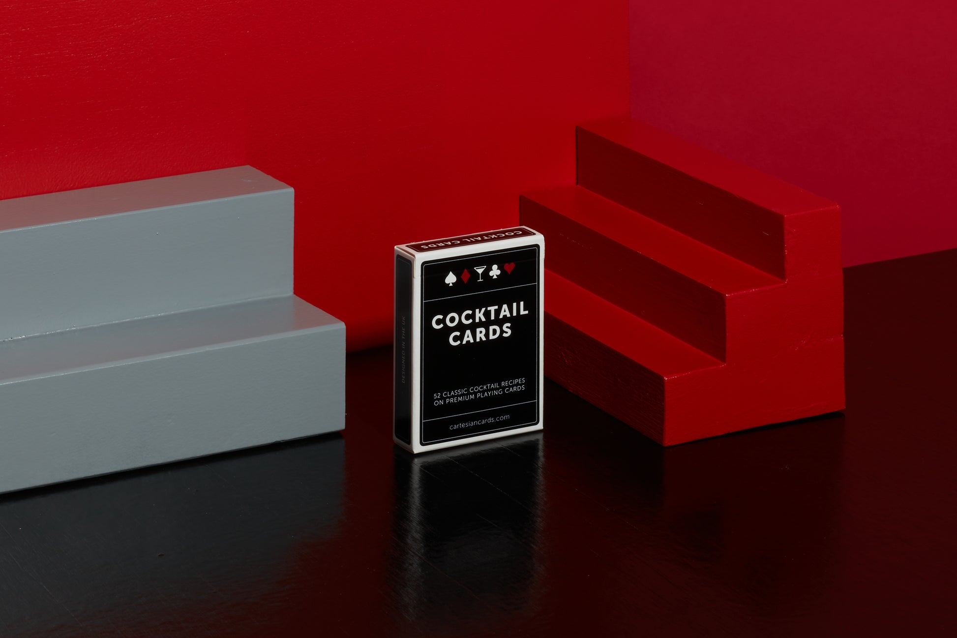 Stylised image of a deck of Cocktail Cards with red geometric objects